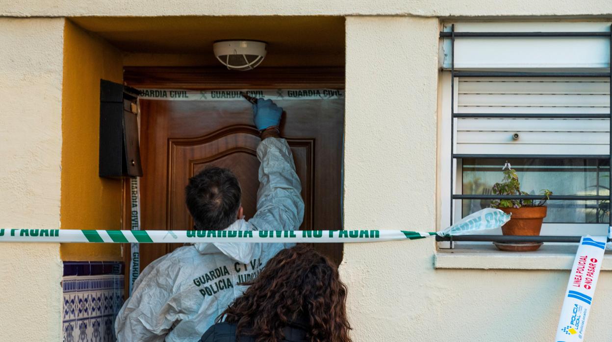 Un agente de la Guardia Civil precinta la vivienda de Castilleja de la Cuesta donde se produjeron los hechos