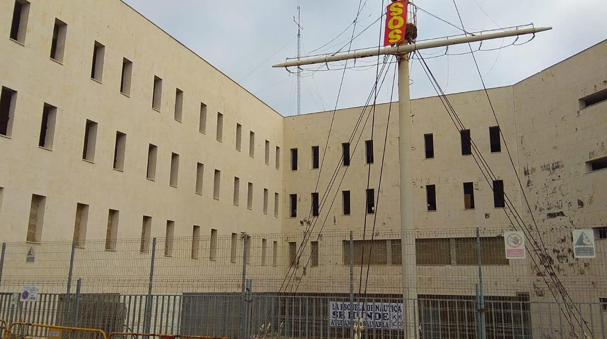 Carteles en la fachada de la vieja Escuela de Náutica que piden su rehabilitación