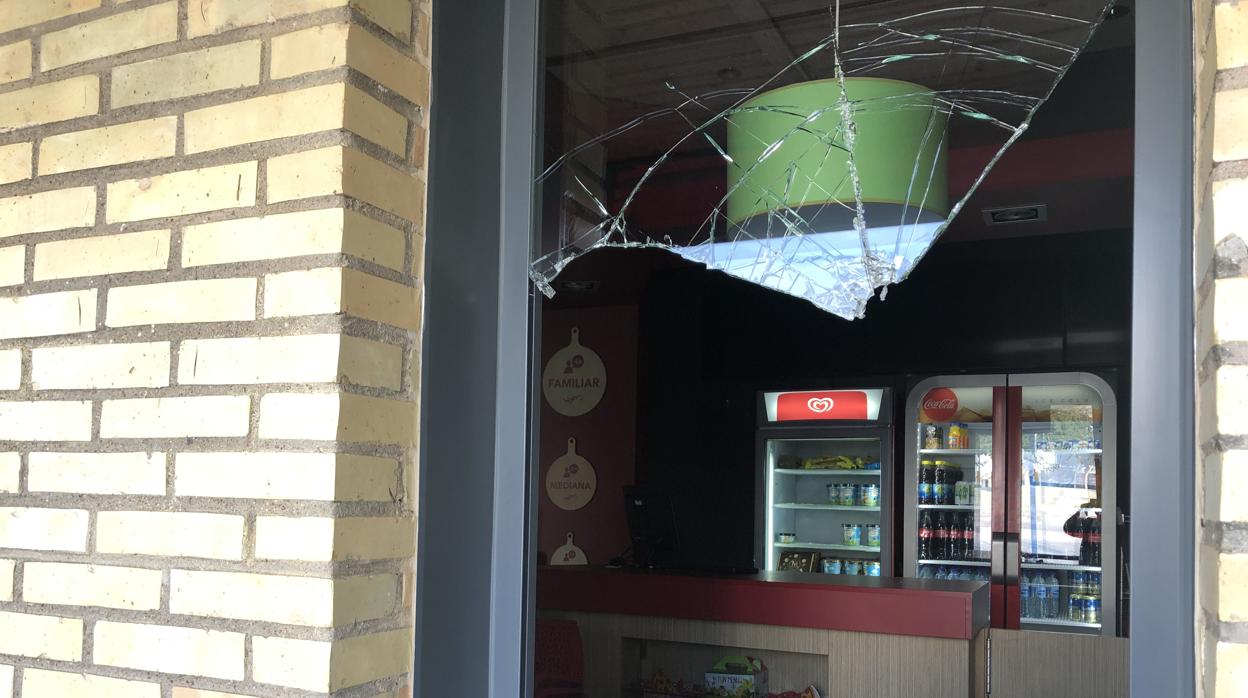 Estado en el que ha quedado la ventana del establecimiento de Telepizza en Arahal