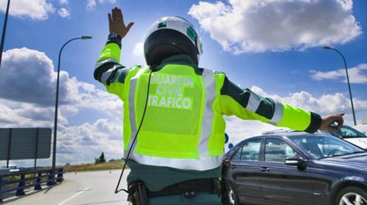 Un agente de la Guardia Civil de Tráfico hace indicaciones al conductor de un vehículo