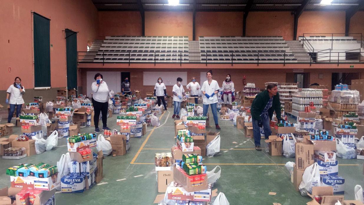 Trabajadores municipales de Lebrija preparando los 500 lotes de alimentos que se repartirán a otras tantas familias con escasez de recursos