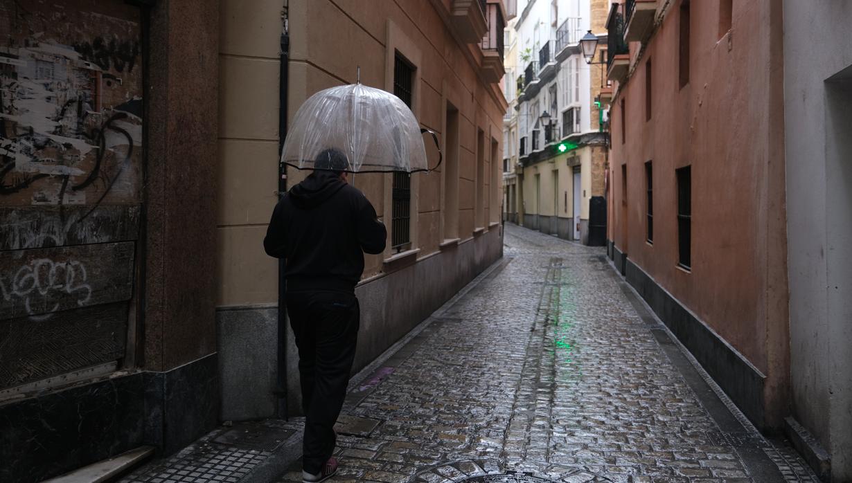 Un ciudadano camina bajo la lluvia en Cádiz.