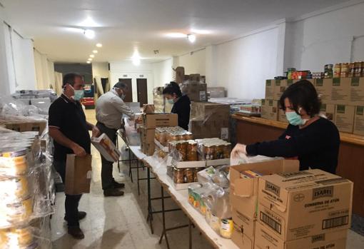 Cuatro voluntarios se dedican a repartir los alimentos