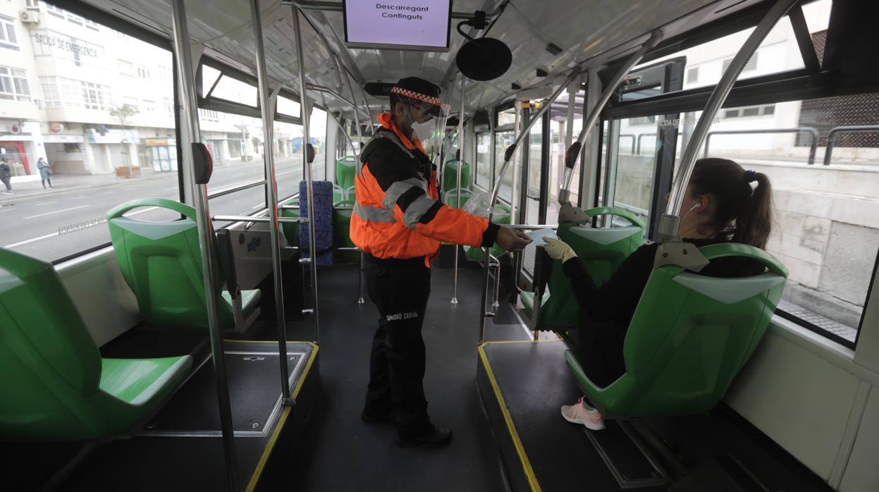 Reparto de entrega de mascarillas en un autobús, en la parada del Puerta del Mar de Cádiz capital.