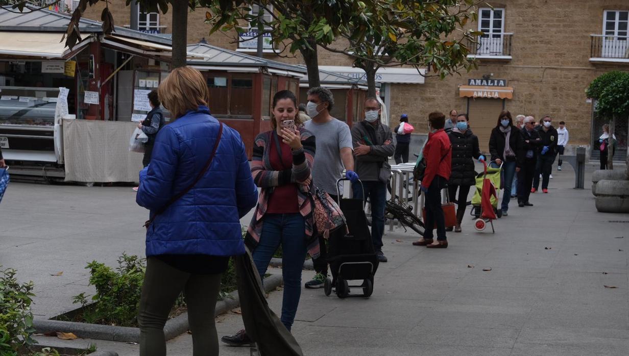 Cola de gente esperando para hacer la compra en un supermercado del casco histórico de Cádiz.