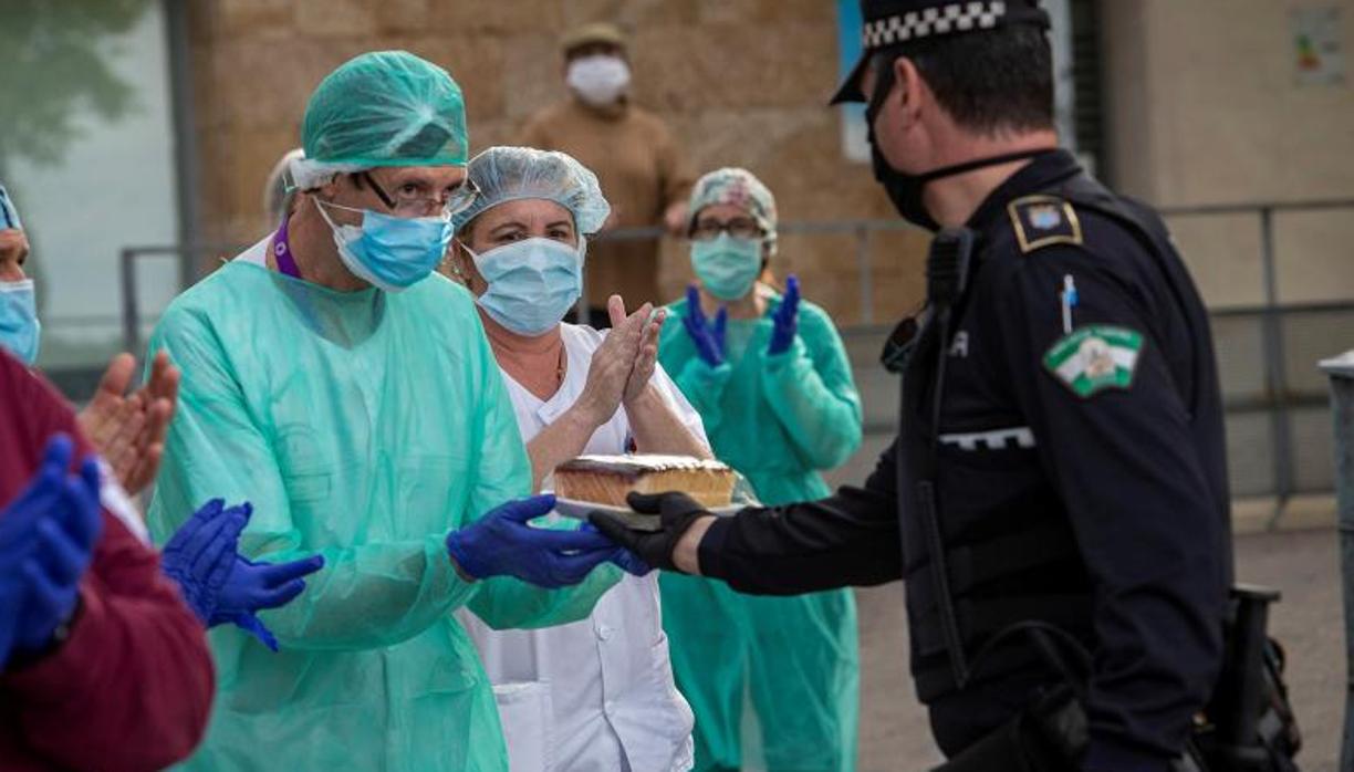 Un agente ofreciendo bizcocho a sanitarios del hospital de Jerez.