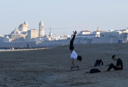 Jóvenes hacen deporte en la playa.