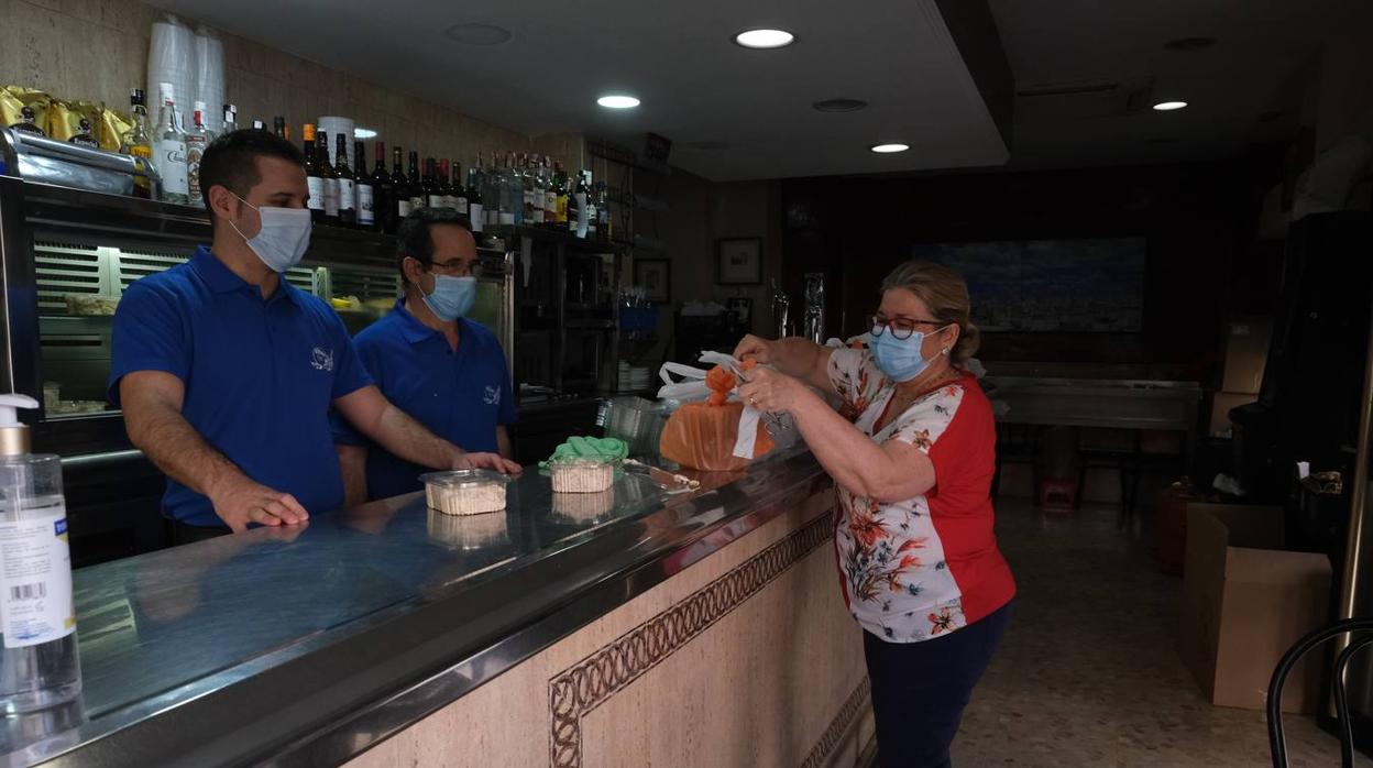 Una clienta recoge su pedido en un bar en la fase 0 de la pandemia en Cádiz.