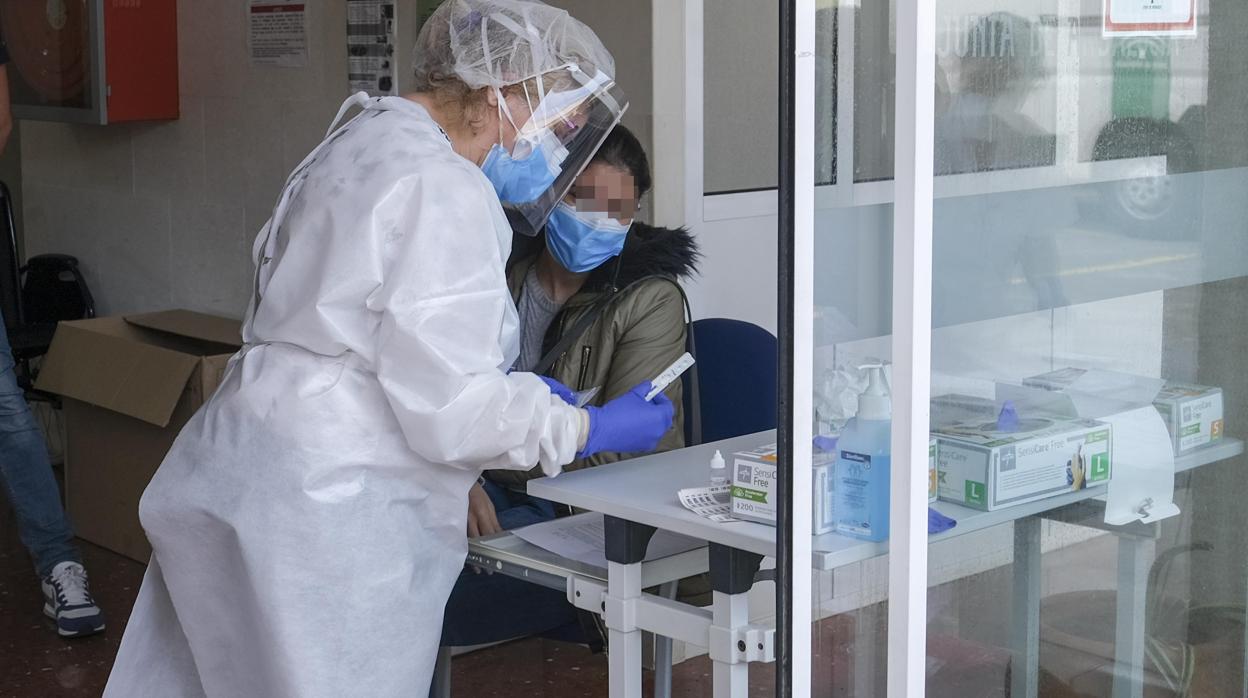 Una enfermera realiza un test rápido a una sanitaria.