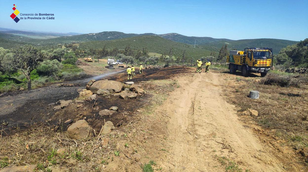 Bomberos tras actuar en el incendio de pasto y matorral en Benalup.