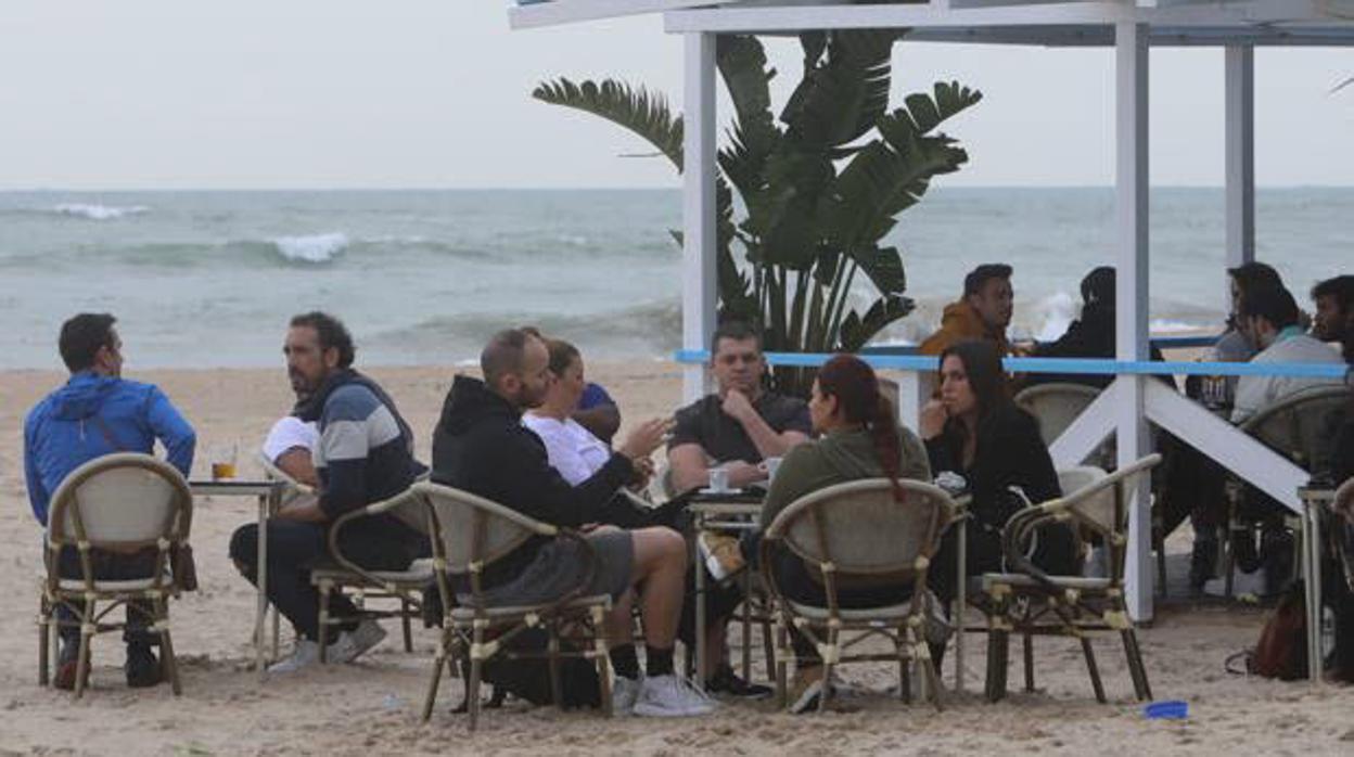 Personas sentadas en la terraza de un chiringuito de Cádiz.