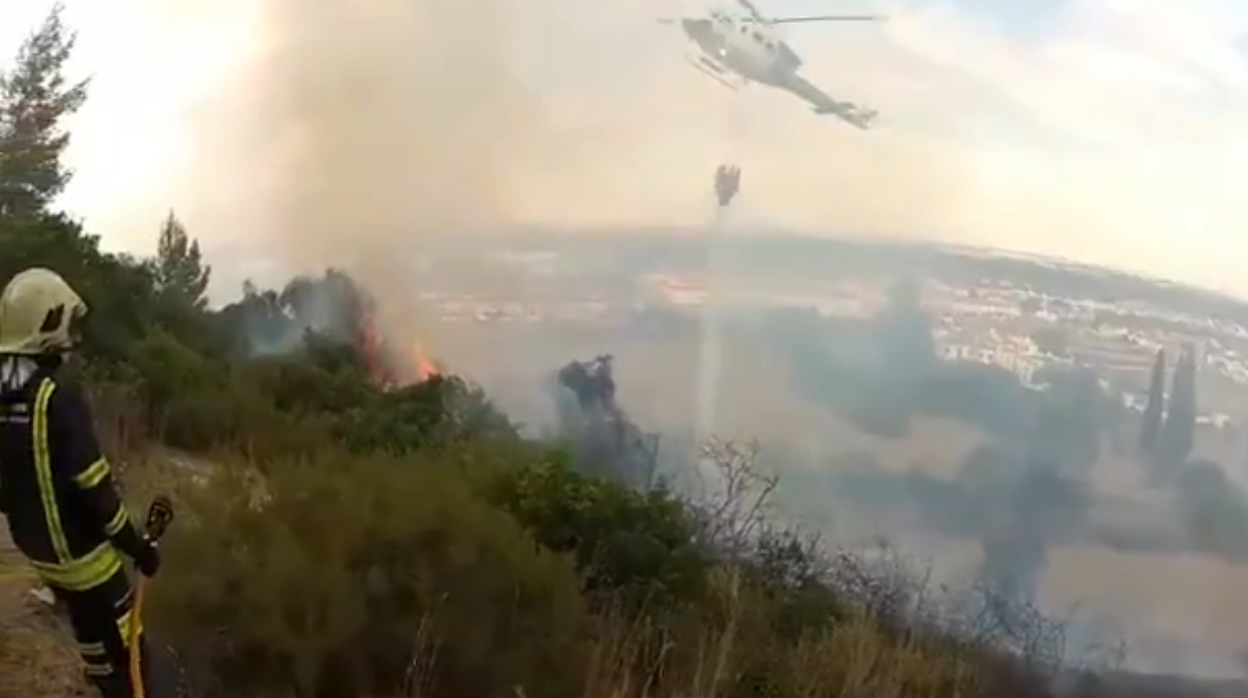 Un helicóptero del Infoca descarga agua sobre la cornisa del Aljarafe