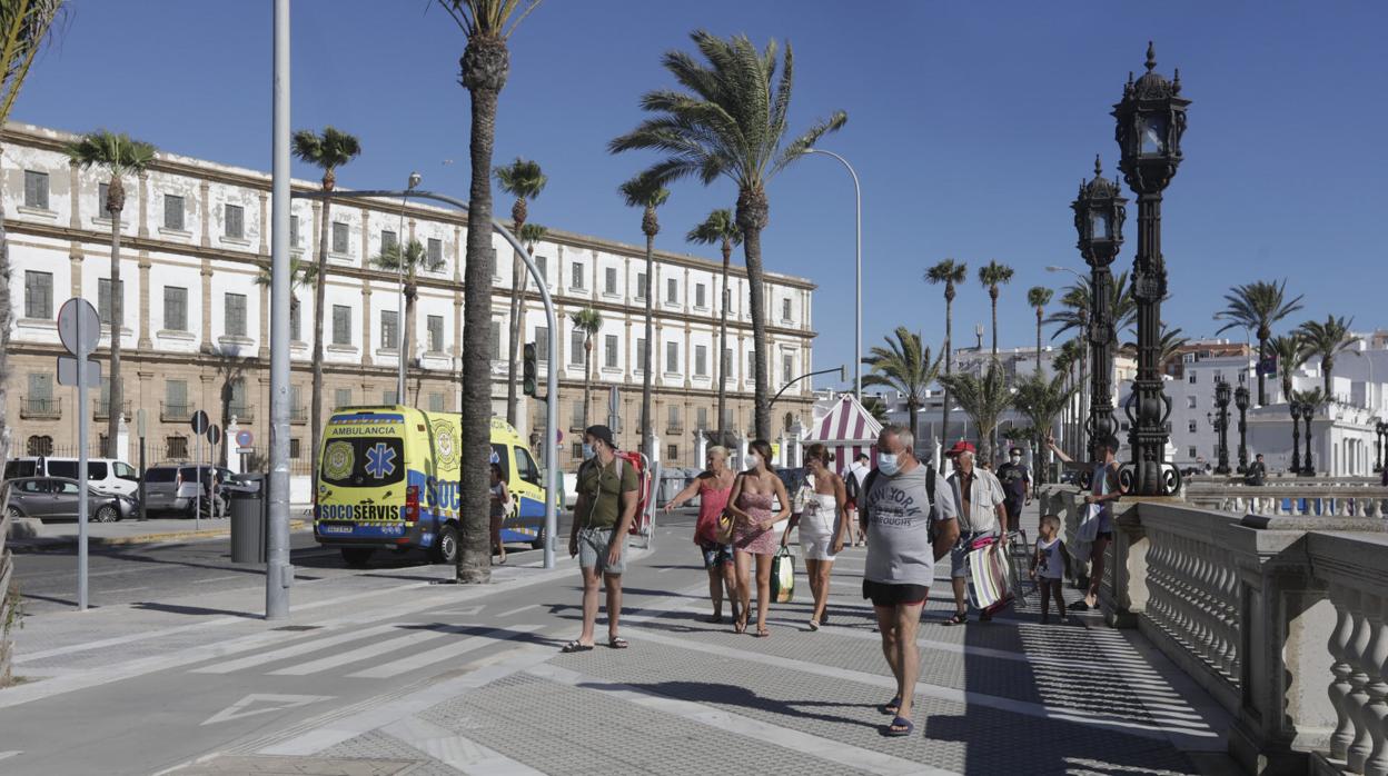 Gente paseando en el entorno de la playa de La Caleta en Cádiz.