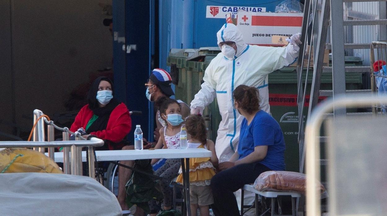 Un sanitario da instrucciones a varios inmigrantes en Cartagena.