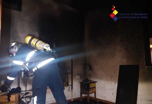 Bomberos durante la actución en el interior del piso incendiado en Conil.