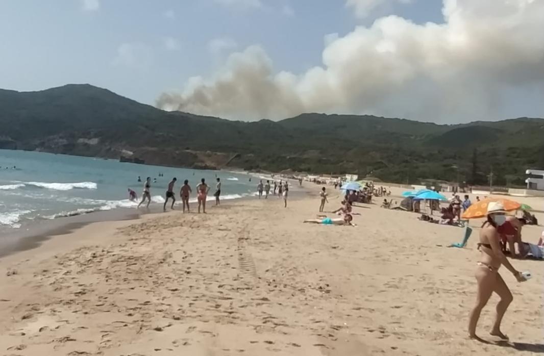 El humo es visible por los bañistas que se encuentran en la playa de Getares.