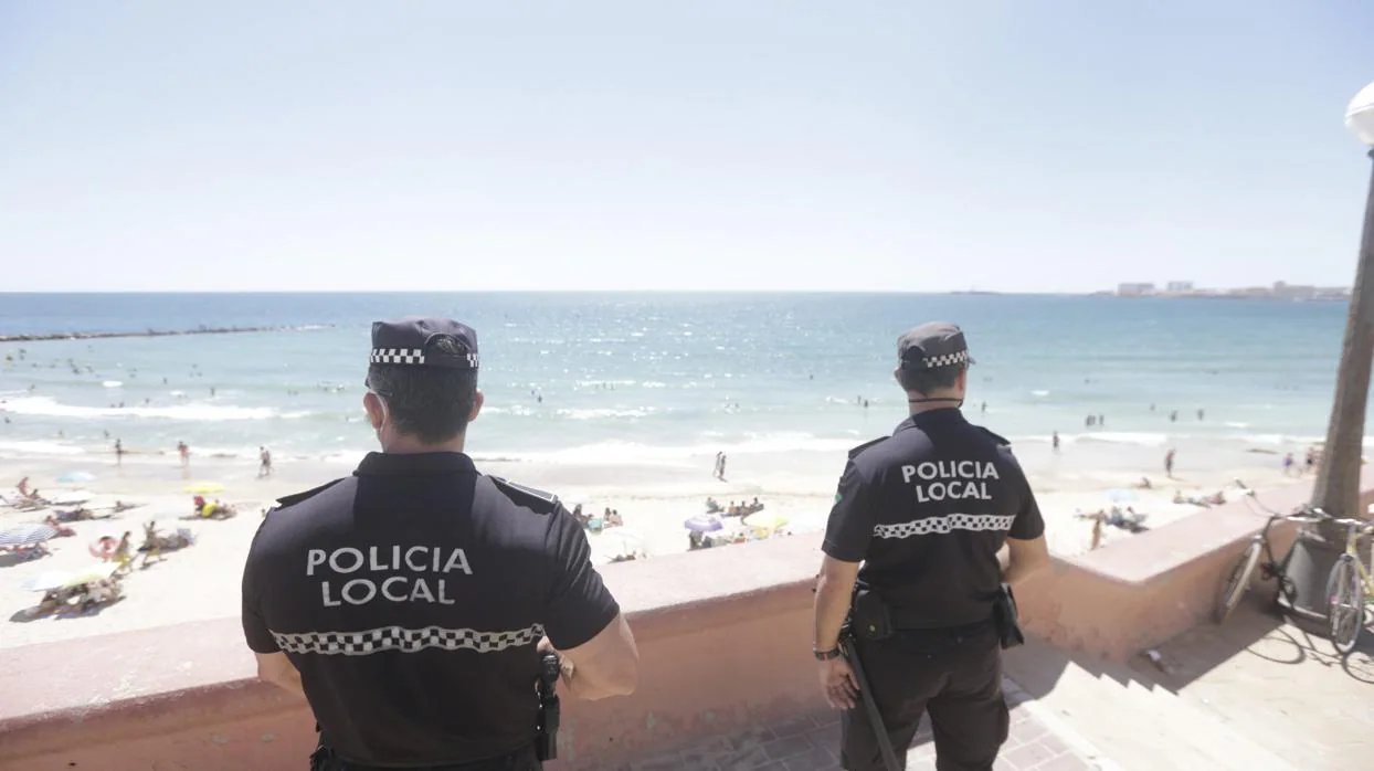 Dos policías locales vigilan la playa en Cádiz.