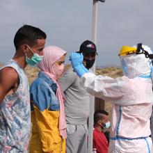 Los sanitarios practicando el protocolo de seguridad por el Covid a los migrantes.