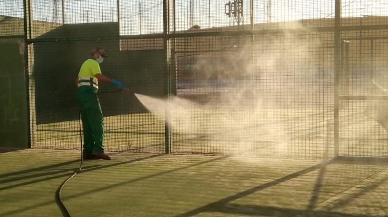 Un operario municipial realiza tareas de desinfección en una pista de pádel de Casariche