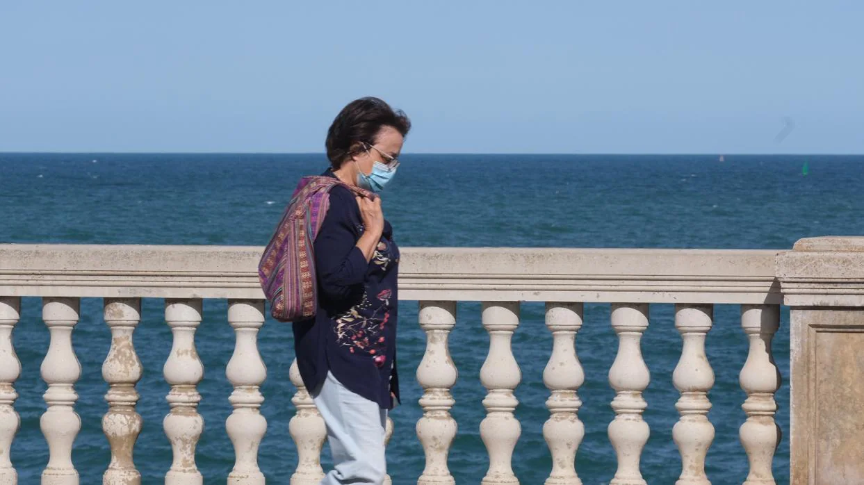 Una mujer con mascarilla paseando por Cádiz.