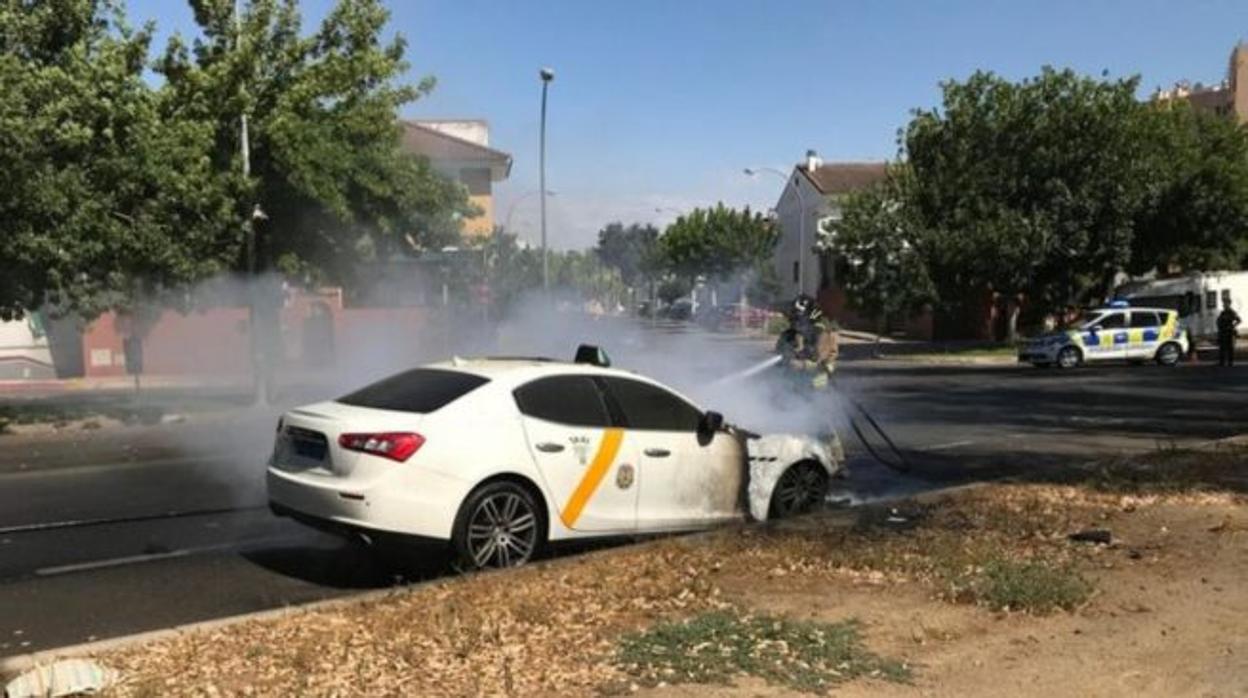 Un bombero apaga las llamas del taxi Maserati, el pasado 11 de agosto