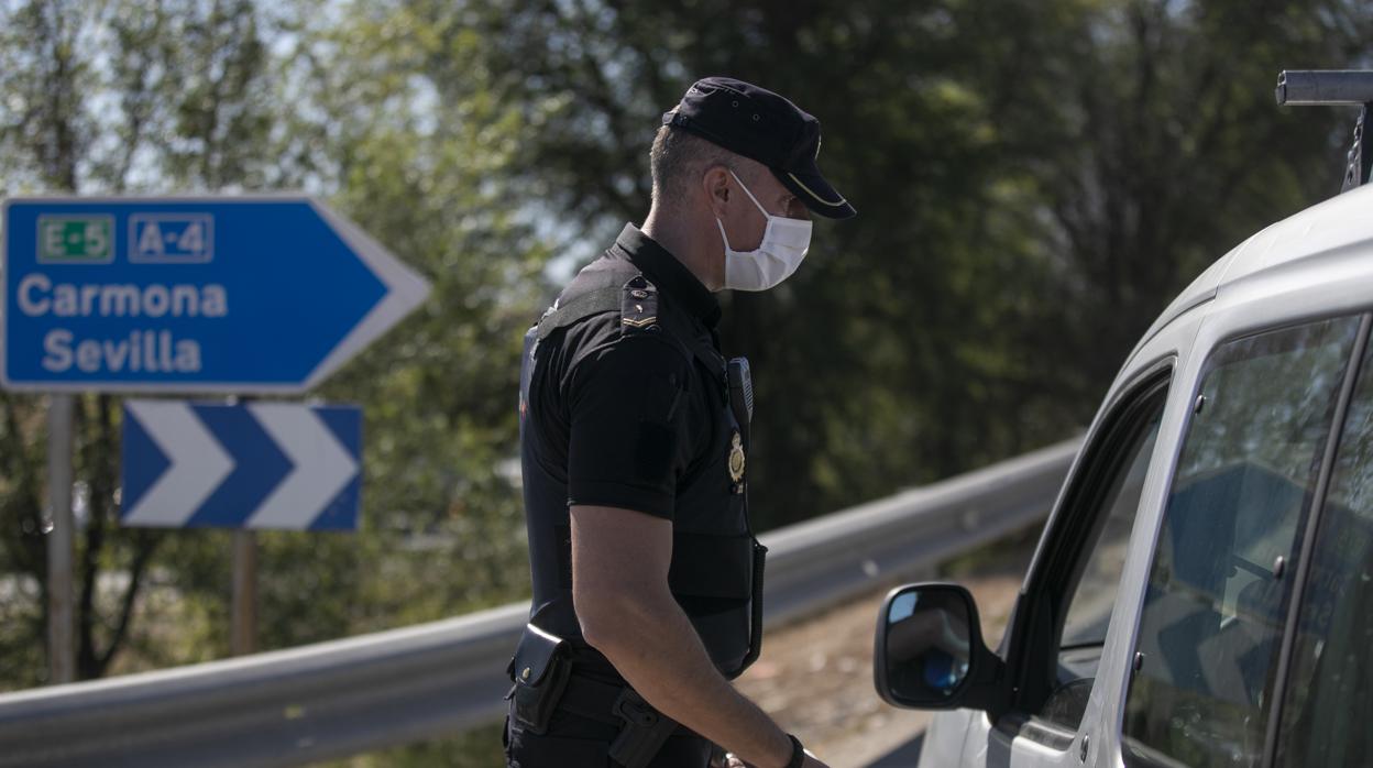 Un agente de la Policía Nacional en un control a la entrada de Écija, el primer día del confinamiento