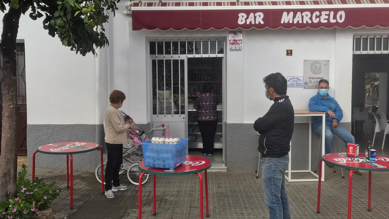Vecinos de El Madroño hacen cola para entrar en un establecimiento