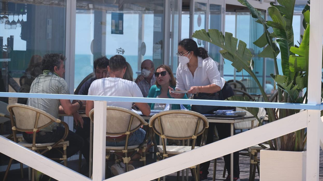 Una camarera atiende a los comensales en un chiringuito de Cádiz capital.