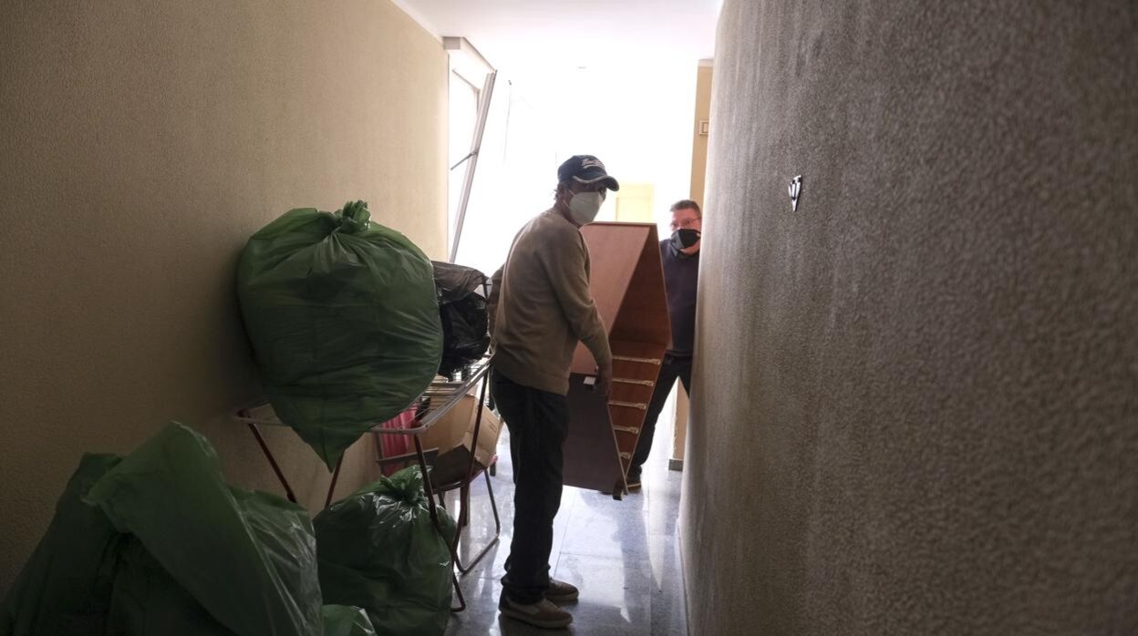 Algunos de los afectados por el desalojo preparan su salida y sacan sus enseres de las viviendas.