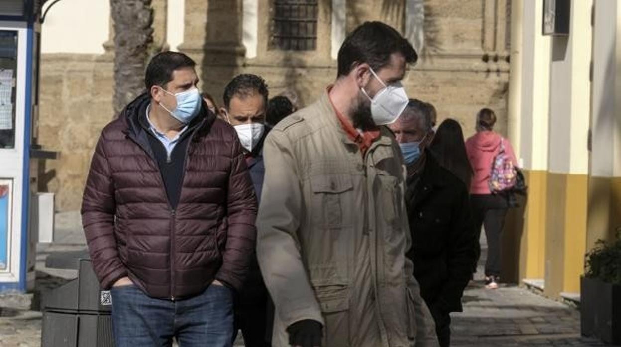 Gaditanos pasean con sus mascarillas para protegerse frente al coronavirus.