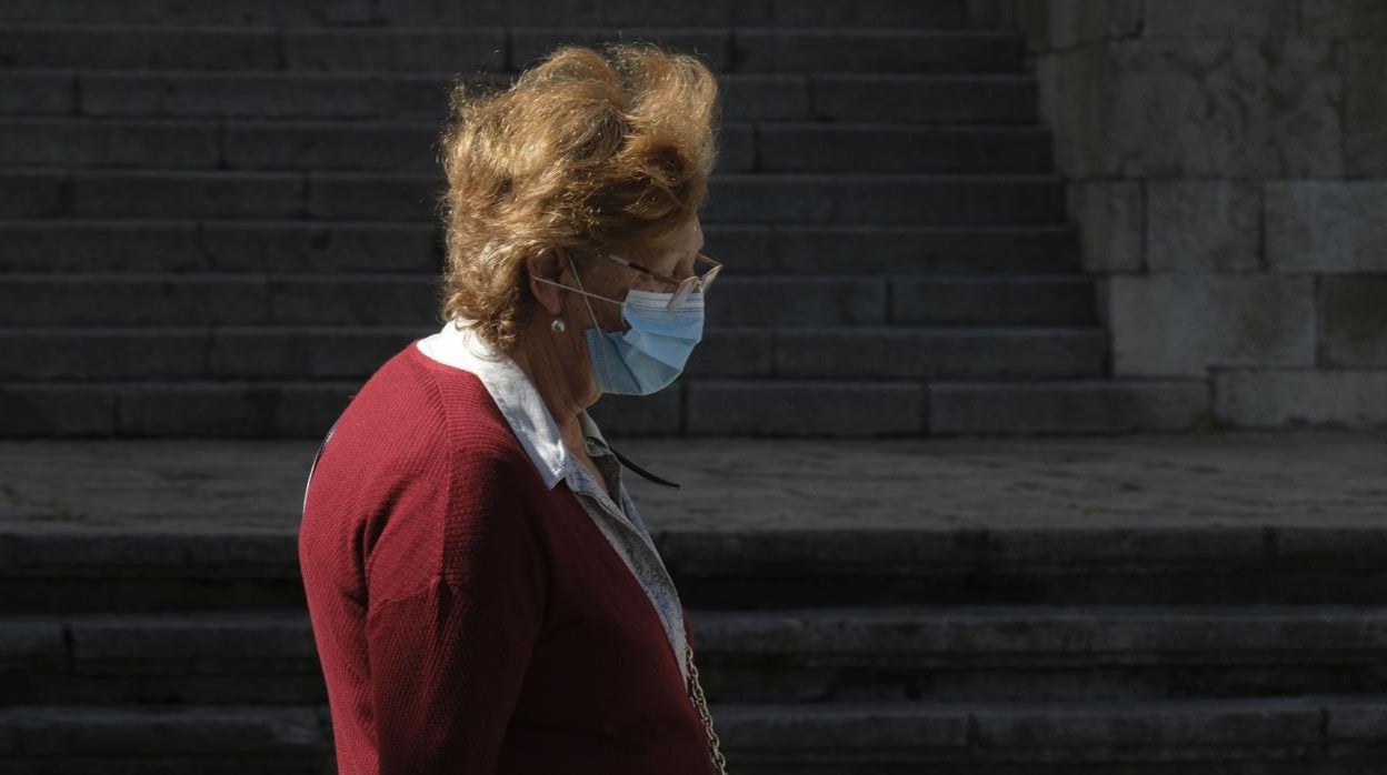 Una gaditana pasea con mascarilla para protegerse del covid en Cádiz.