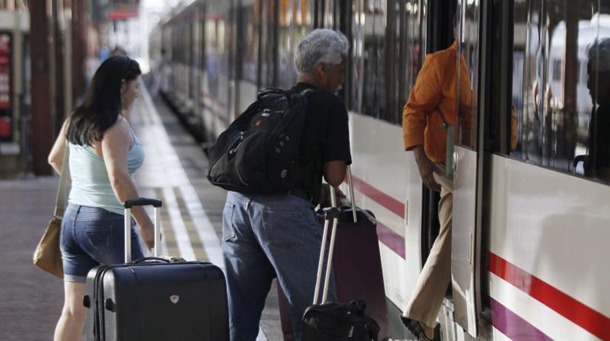 Varios pasajeros se suben a un tren de media distancia