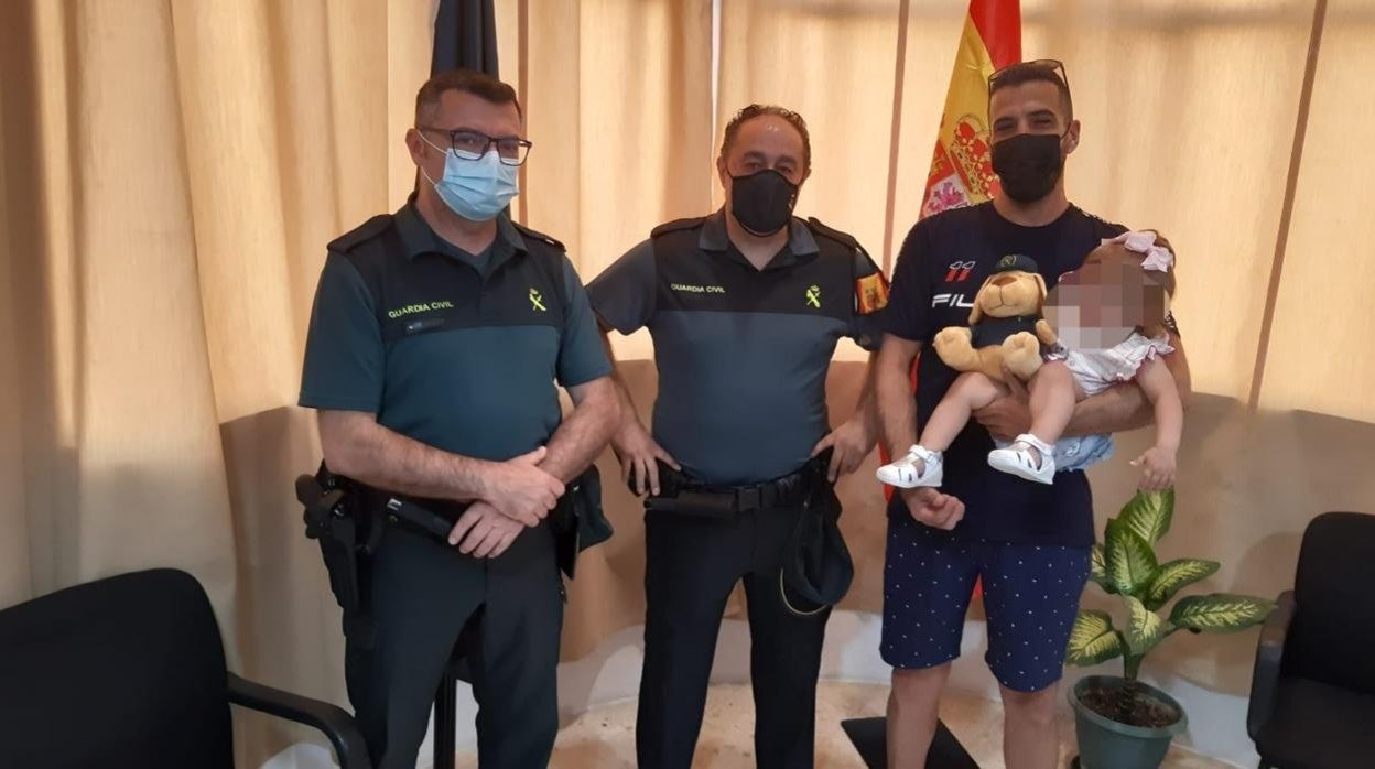 Agentes de la Guardia Civil, con la bebé auxiliada cuando se ahogaba en una piscina en Mairena del Alcor, Sevilla