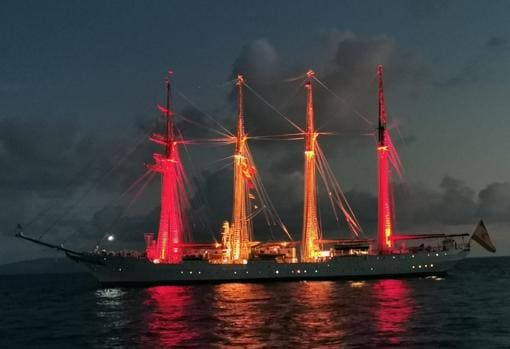 El buque, iluminado con la bandera de España, en Guam.