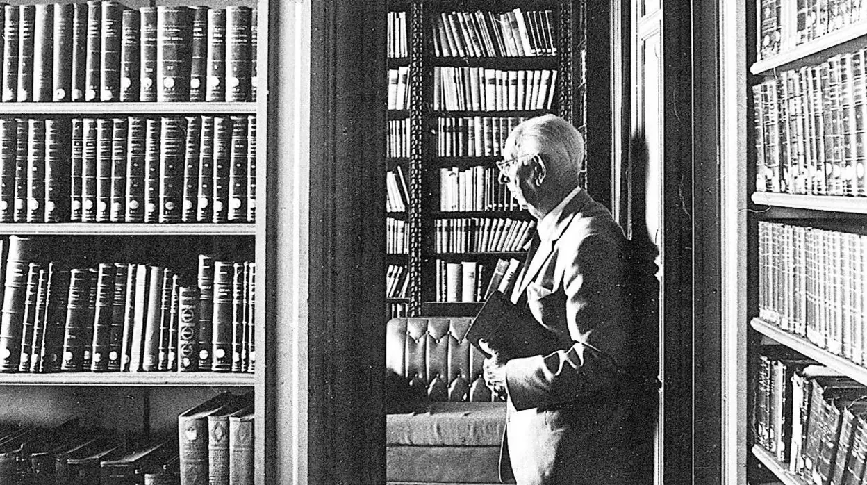 José María Pemán, rodeado de libros en su biblioteca.