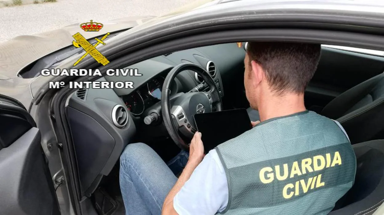 Un guardia civil realiza una inspección en un vehículo
