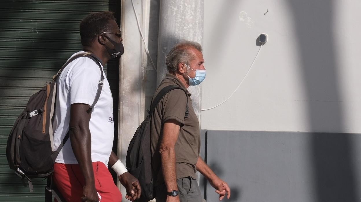 Dos personas paseando con mascarilla por Cádiz.