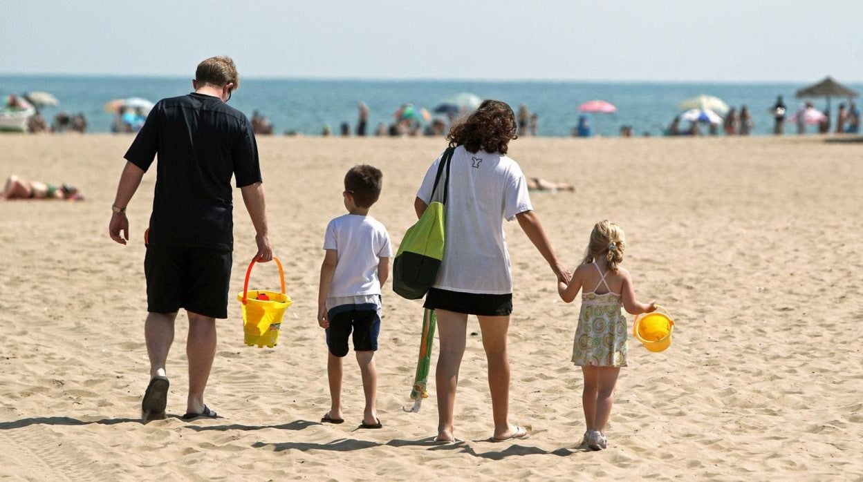 Imagen de archivo de unos niños en la playa con sus padres.