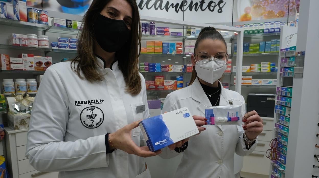 Dos farmacéuticas muestran un test de autodiagnóstico.