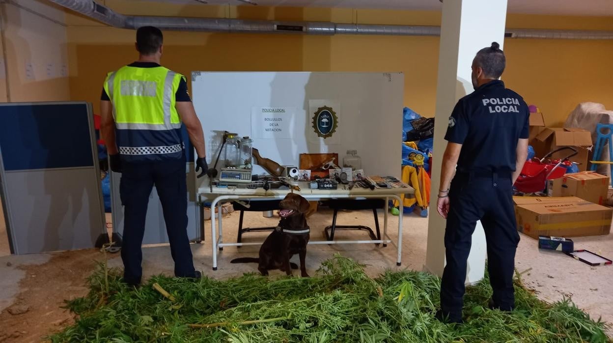 Dos agentes policiales con el material inacutado en un domicilio de Bollullos de la Mitación