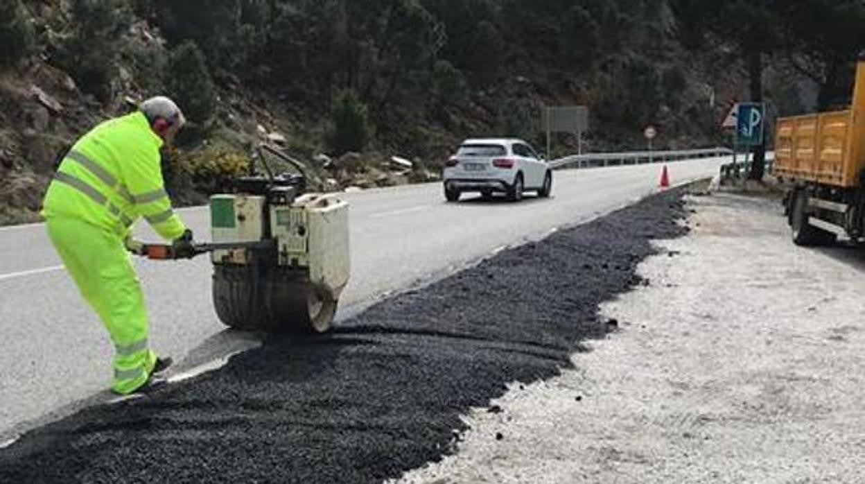 Un operario durante el refuerzo del firme en una carretera de la provincia de Sevilla