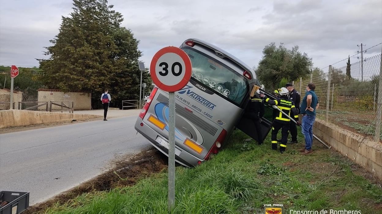 El autobús, en la vía, semivolcado.