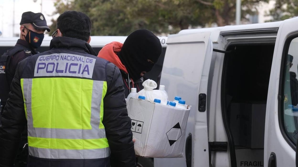 Los agentes sacan de la casa donde se preparaba la droga los productos químicos intervenidos.