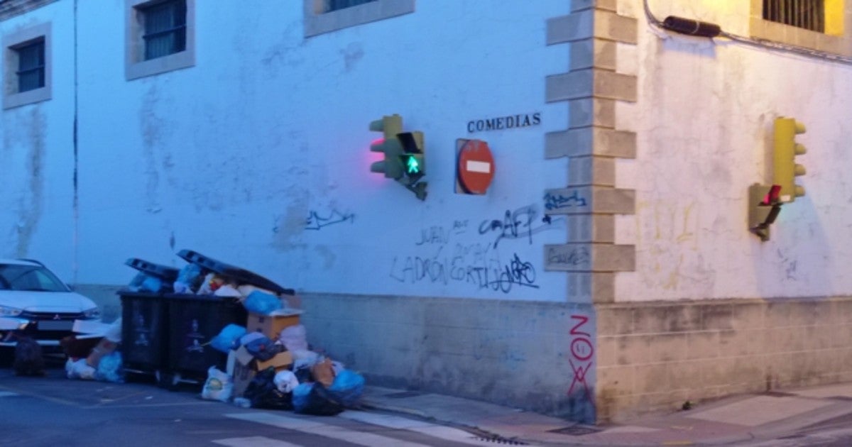 Varios contenedores repletos de bolsas de basura en la calle Comedias