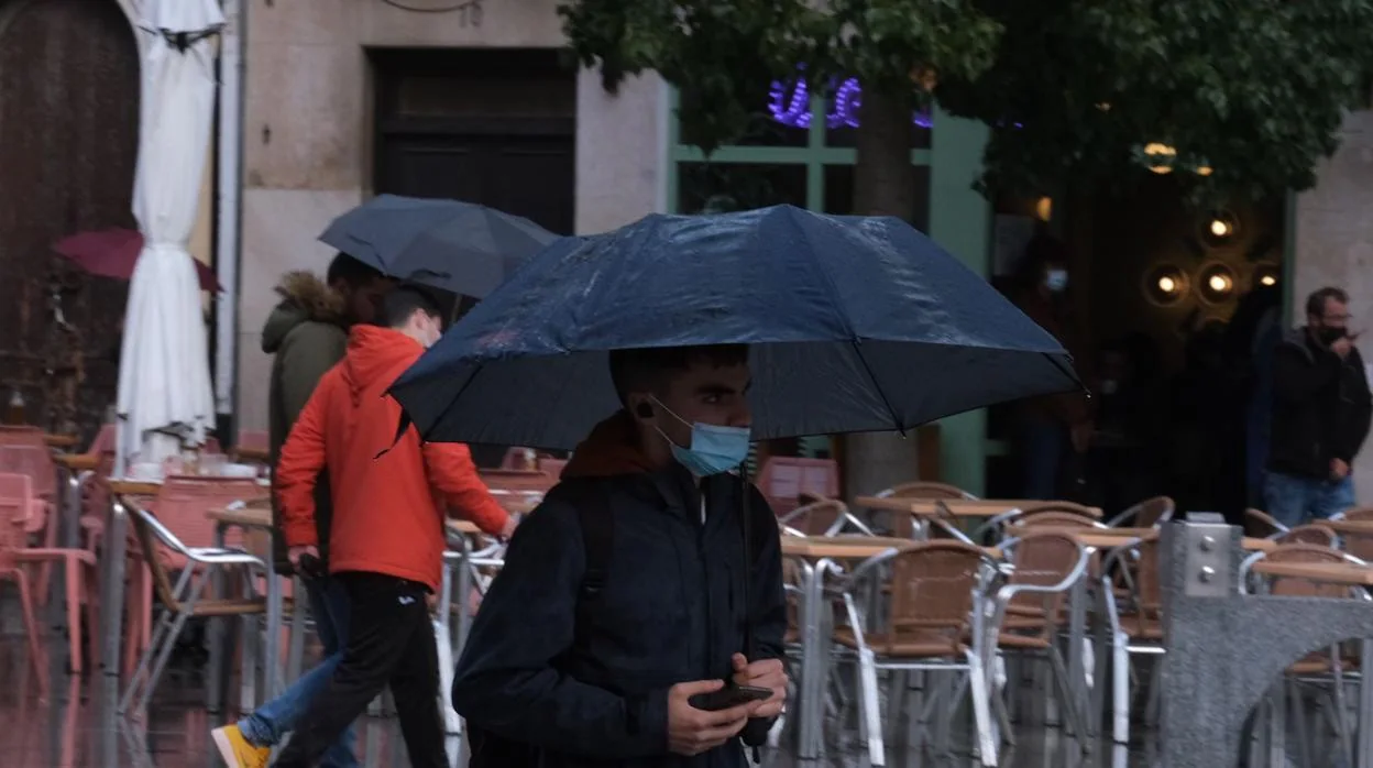 Peatones durante las precipitaciones, este lunes, en la plaza de San Juan de Dios de Cádiz.