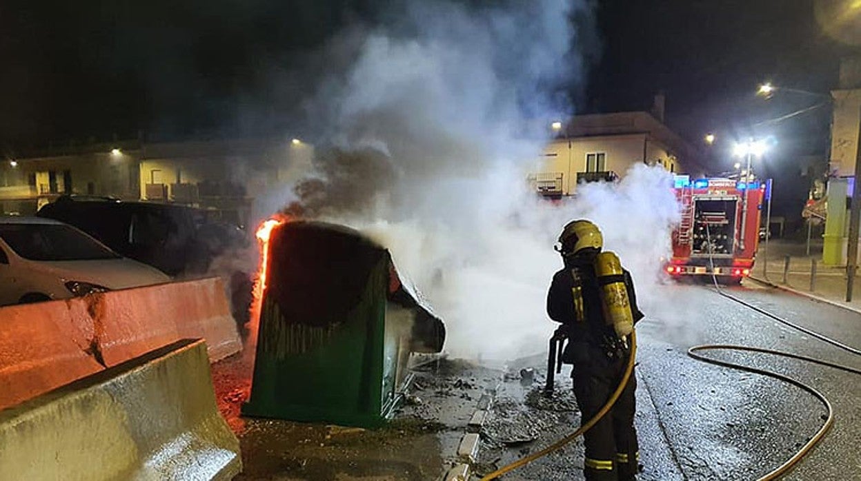 Los bomberos empleándose a fondo para apagar el fuego de un contenedor en Utrera