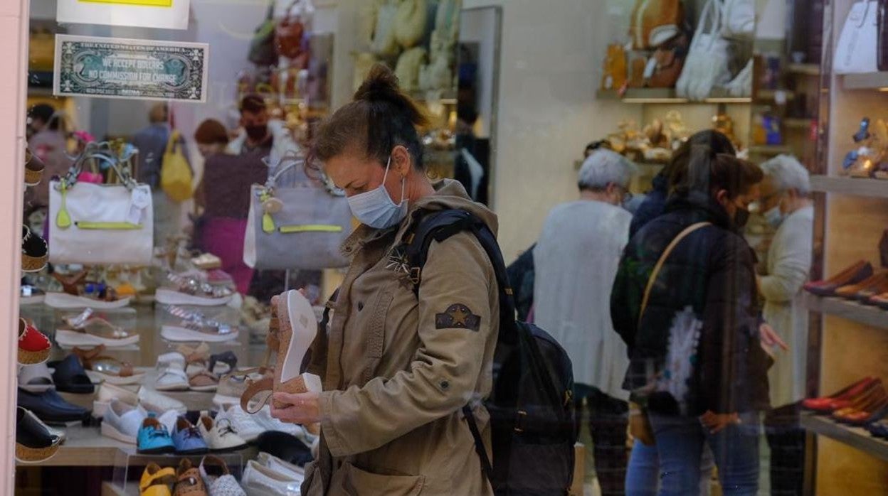 Personas dentro de una tienda en el último día con mascarilla obligatoria en el interior.