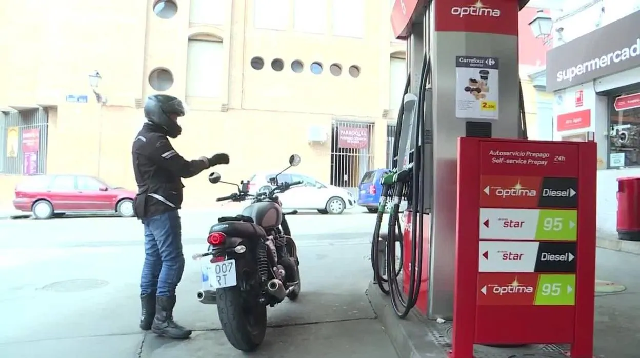 Una motorista reposta combustible en una gasolinera