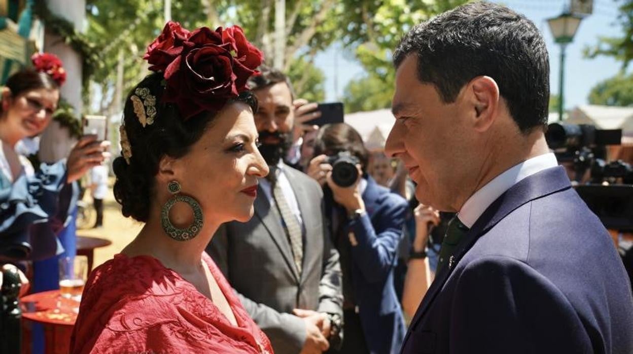 Macarena Olona y Juanma Moreno mirándose cara a cara en la Feria de Sevilla.