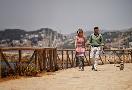 Juanma Moreno y su esposa, paseando por Málaga este sábado de reflexión.